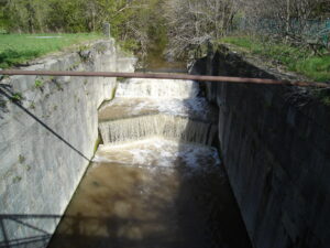 The stone walls of an abandoned lock chamber of the Second Welland Canal in Merritton, St. Catharines, Ontario, overgrown remnants of the neighbourhood's 19th-century canal industrial heritage.