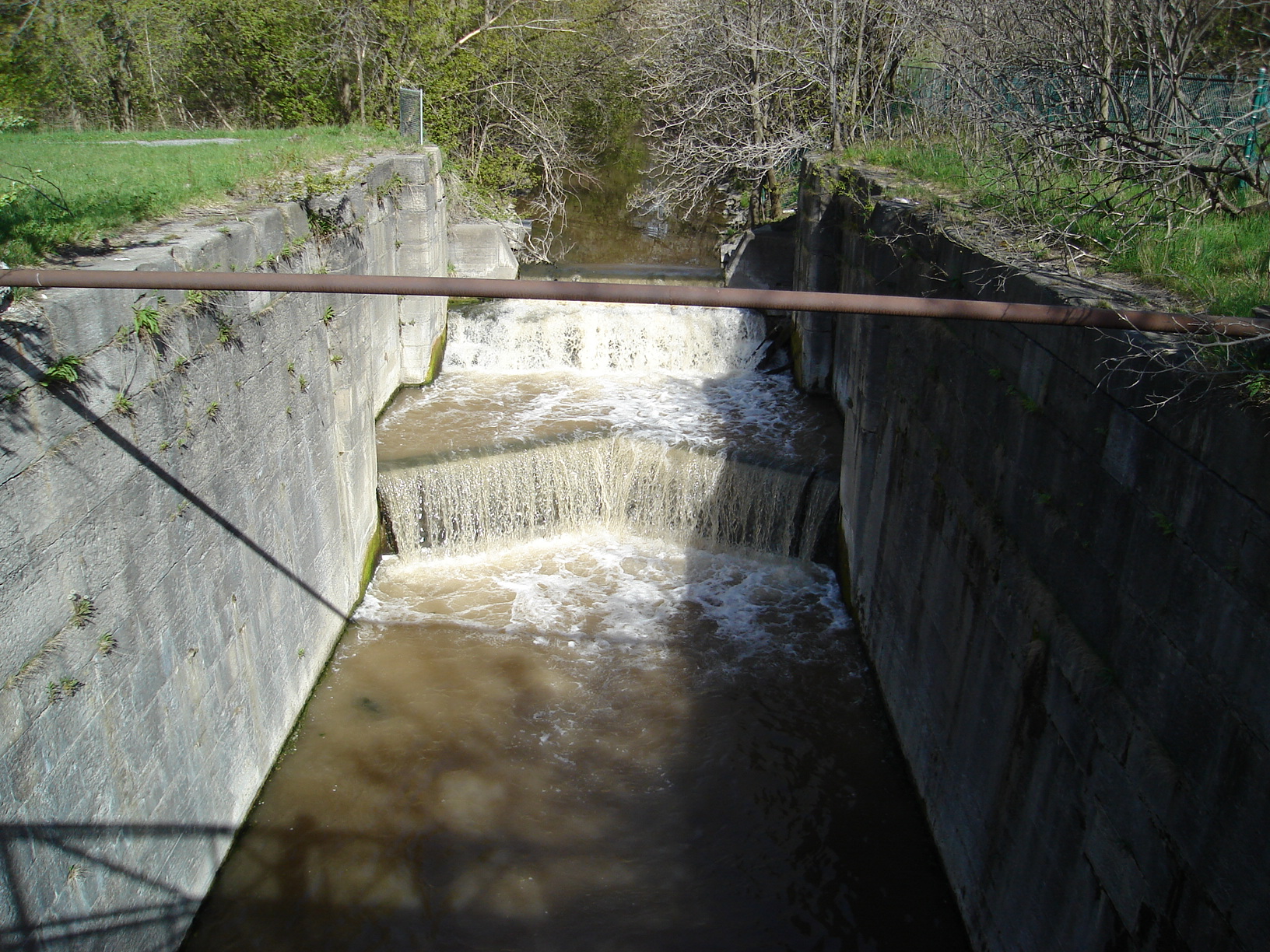 The stone walls of an abandoned lock chamber of the Second Welland Canal in Merritton, St. Catharines, Ontario, overgrown remnants of the neighbourhood's 19th-century canal industrial heritage.